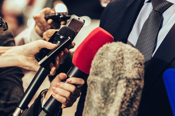 Journalists interviewing business person on public event