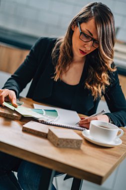 Genç mimar veya evden çalışma ve not defterinde yazılı iç mekan tasarımcısı 