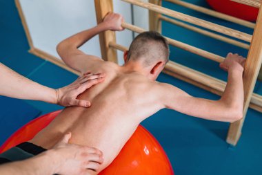 Fizyoterapist genç çocuk ile yapıyor