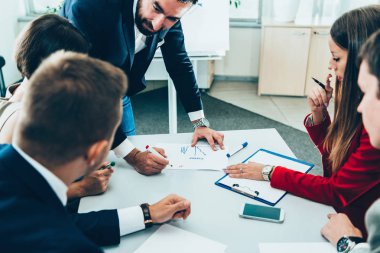 office toplantıda işadamları. Lider ayakta ve meslektaşları için konuşuyor