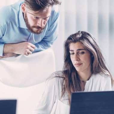 Baskı altında çalışmak. Genç ve ciddi takım lideri toplantıda yeni bayan çalışana önemli talimatlar veriyor..