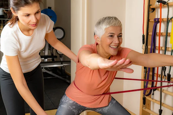 Mujer Mayor Activa Haciendo Sentadillas Instructora Ayudándola — Foto de Stock