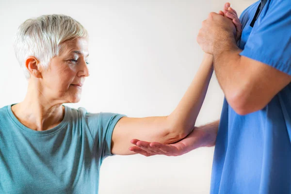 Therapeut Checking Senior Womans Arm Fysiotherapie Office — Stockfoto