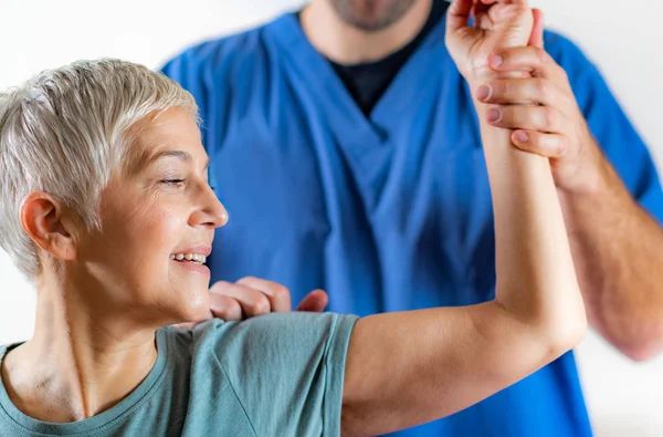 Therapeut Checking Senior Womans Arm Fysiotherapie Office — Stockfoto