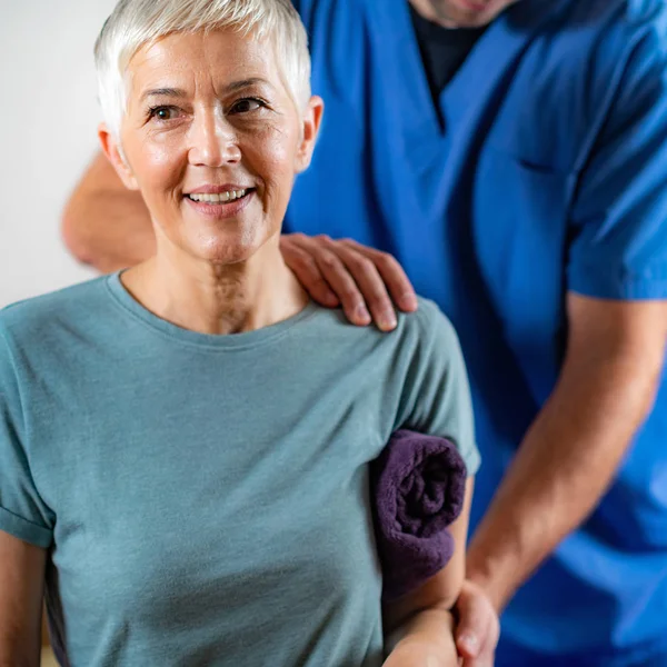 Therapeut Checking Senior Womans Arm Fysiotherapie Office — Stockfoto