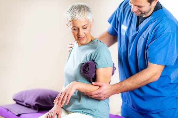 Θεραπευτής Έλεγχος Senior Womans Arm Στο Γραφείο Φυσικοθεραπείας — Φωτογραφία Αρχείου