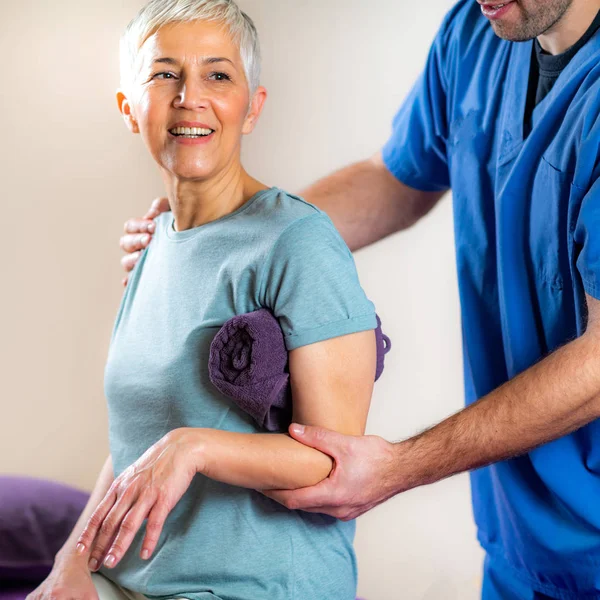 Therapeutin Überprüft Arm Von Seniorin Physiotherapiepraxis — Stockfoto