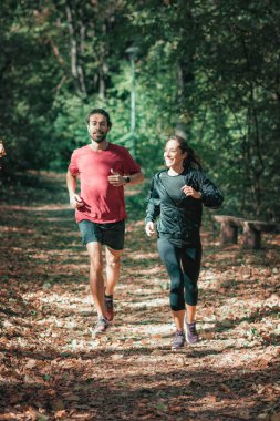 Genç bir çift parkta koşuyor. Doğa, yeşil arkaplan.