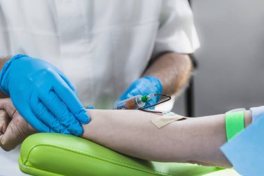 Trombosit zengini plazma yüz tedavisi için kan alınıyor. Doktorun elinde mavi ameliyat eldiveni Prp yüz estetik tedavisi için kan alıyor.. 