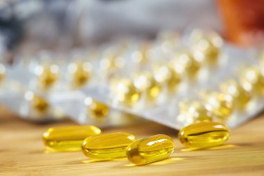 Omega 3 takviyeleri. Softgel destek kapsülleri ve arka planda tam su toplaması