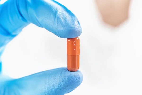 Scienziato Mano Guanto Tenendo Pillola Arancione Con Guanto Blu Laboratorio — Foto Stock