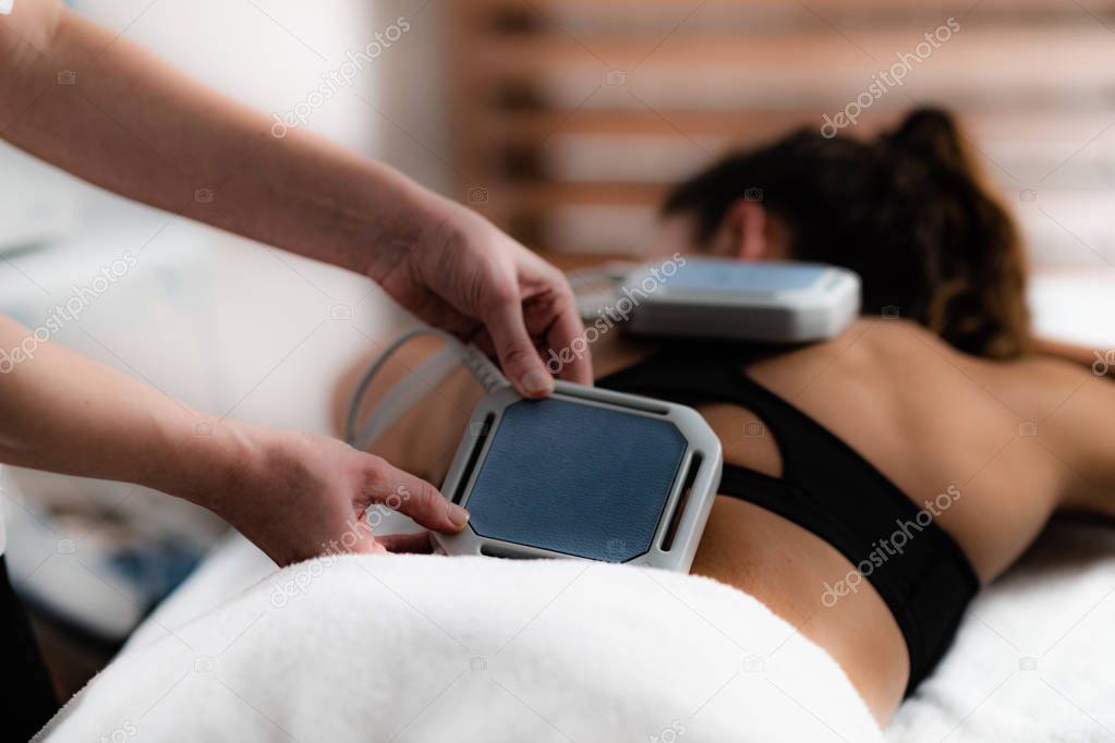 Magnet therapy. Magnets used in physical therapy, placed to patient's lower back.