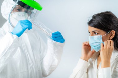 Coronavirus belirtileri. Sıhhiyeci kan oksijeni seviyesini oksimetreyle ölçüyor. Hasta koruyucu maske takıyor.