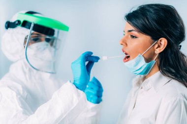 Coronavirus belirtileri. Sıhhiyeci kan oksijeni seviyesini oksimetreyle ölçüyor. Hasta koruyucu maske takıyor.