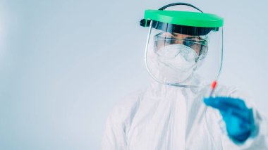 Corona Virüsü Testi - Beyaz Hazmat koruyucu süitinde PCR DNA testi için örnek alınan sağlık görevlisi 
