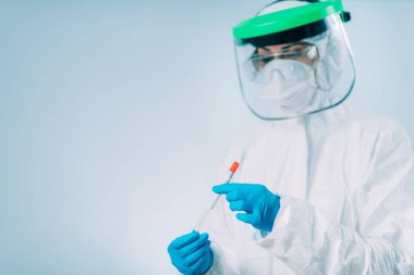 Corona Virüsü Testi - Beyaz Hazmat koruyucu süitinde PCR DNA testi için örnek alınan sağlık görevlisi 