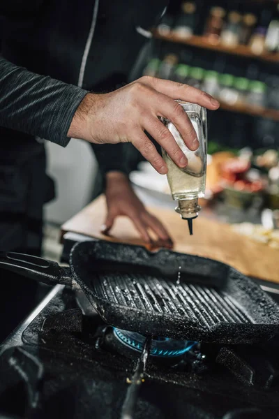 レストラン料理 焼き鍋に油を注ぐシェフ — ストック写真