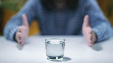 Telekinezi genç adam telekinetik güçler geliştirmeye çalışıyor, bir bardak suyla pratik yapıyor. 