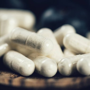 Trans-Pterostilbene takviyeleri. Antioksidan besinlerle çevrili. Yaban mersini, kırmızı üzüm ve badem. Yakın çekim, takviyeye odaklan.