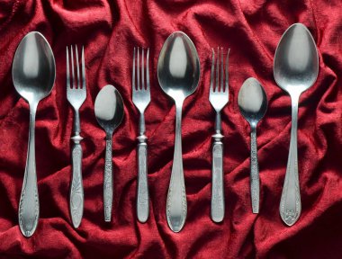 Vintage çatallarla kaşıklar üzerinde kırmızı ipek masa örtüsü. Üstten Görünüm.