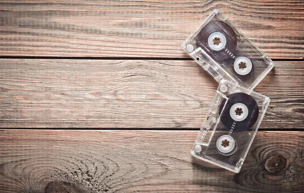 Due cassette audio su un tavolo di legno. Tecnologia retrò degli anni '80. L'amore per la musica. Ricevuto. Vista dall'alto . — Foto Stock