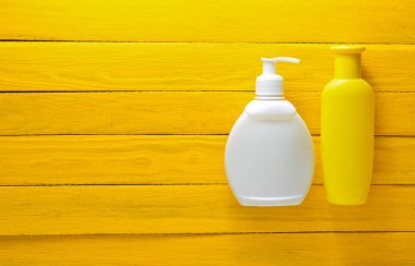 Losyon ve sarı ahşap kurullarında güneş kremi. Denizde tatil için aksesuarlar. Üstten Görünüm.