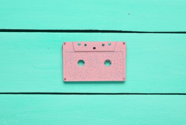 Turkuaz ahşap arka plan üzerinde Retro ses kaset. Minimalizm eğilimini. Eski radyo sinyalleriyle iletilen teknoloji kavramı. Üstten Görünüm. 