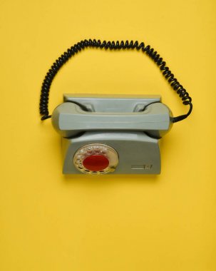 Sarı bir arka plan döner bir retro telefonda. Üstten Görünüm.