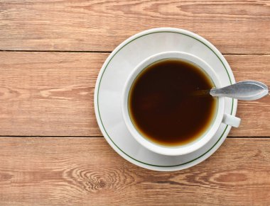 Beyaz fincan kahve ahşap bir masa üzerinde. Üstten görünüm.