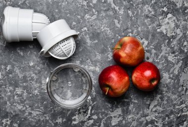 El juicer ve elma beton bir tablo. Sağlıklı gıda kavramı. Pişirme işlemi. Üstten görünüm. Rustik ve çatı stili.