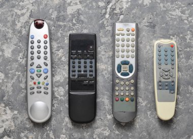 Birçok Tv Uzaktan kumanda gri beton masada. Üstten görünüm. Uzaktan kumanda ev aletleri ve elektronik.