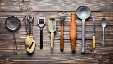 Eski mutfak aletleri ve çatal bıçak takımı ahşap bir masa üzerinde bir dizi. Vintage mutfakta yemek. Üstten görünüm.