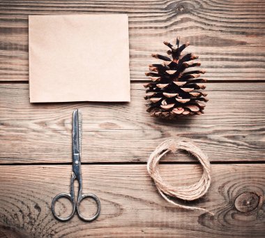 Ahşap bir masa üzerinde DIY için araçlar: kağıt, makas, iplik, koni. Kendi kendine yapılan zarf harfler için. Üstten görünüm. Düz yatıyordu.