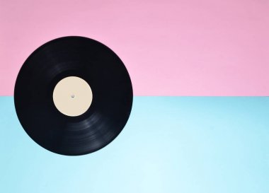 Vinil plaka üzerinde mavi bir pastel pembe. Minimalizm bir eğilim. Retro 70 li yıllarda medyadan. Radyo sinyalleriyle iletilen teknoloji. Üstten görünüm. Kopya alanı.