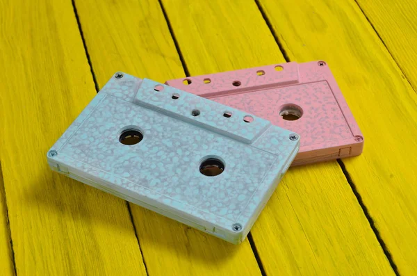 Pembe mavi pastel renk ses kaset sarı bir ahşap zemin üzerine boyanmış. Retro radyo sinyalleriyle iletilen teknoloji.
