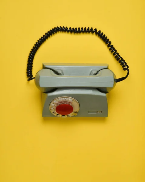En roterande retro telefon på gul bakgrund. Ovanifrån. — Stockfoto