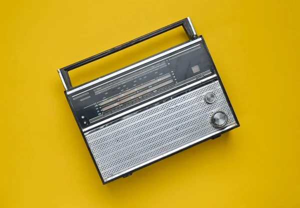 Vista dall'alto di un ricevitore radio retrò su sfondo giallo. Cultura degli anni '70. Vista dall'alto . — Foto Stock