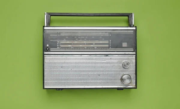 Obsolete retro radio receiver on a green pastel background. Top view.