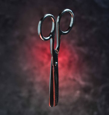 Metal makas beton duvar arka plan üzerinde. Mistik kırmızı ışık.