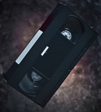 Karanlık bir beton duvar arka plan üzerinde havaya yükselme video kaset. Mistik ışık. 80s Retro teknoloji.