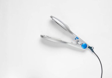 Beyaz bir arka plan üzerinde gümüş rengi için bir saç demir. Saç Bakımı.