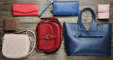 Birçok kadın çanta ve çantalar ahşap arka plan üzerinde. Üstten Görünüm.