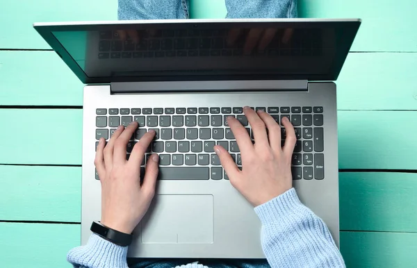 在绿松石木桌上使用笔记本电脑 顶部视图 现代青年 网上工作在互联网上 — 图库照片