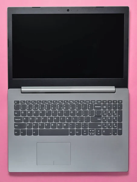 Geöffneter Laptop auf rosa Hintergrund. moderne Computertechnologien. Ansicht von oben. — Stockfoto