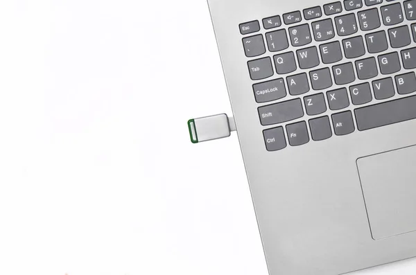 USB flash drive dimasukkan ke dalam laptop yang terisolasi pada latar belakang putih. Media digital modern . — Stok Foto