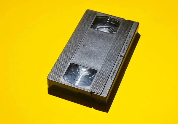 80s sarı bir arka plan üzerinde gelen Retro video kaset. Eski medya teknolojileri.