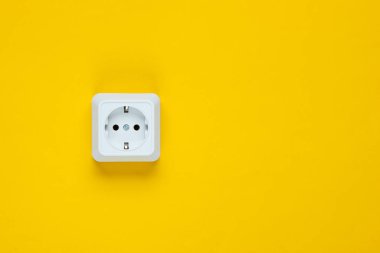 Sarı arka planda beyaz plastik prizler. Kopya alanı olan duvar. Minimalizm