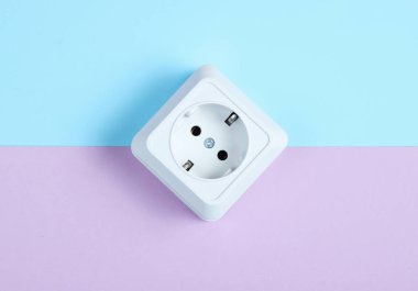 Pastel arka planda beyaz plastik priz. Minimalizm