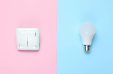 Ekonomi ampulü, pastel arka planı aç. Üst Manzara. Minimalizm elektro tüketici kavramı