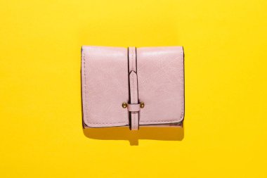 Sarı arka planda pembe deri cüzdan. Üst görünüm